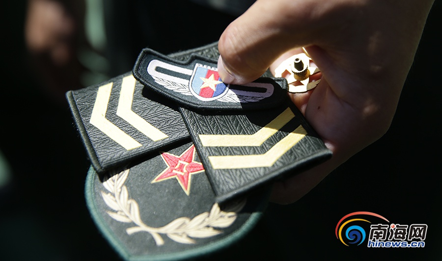 在连队举行的摘军衔仪式上战友将伍国栋的军衔领章摘下.